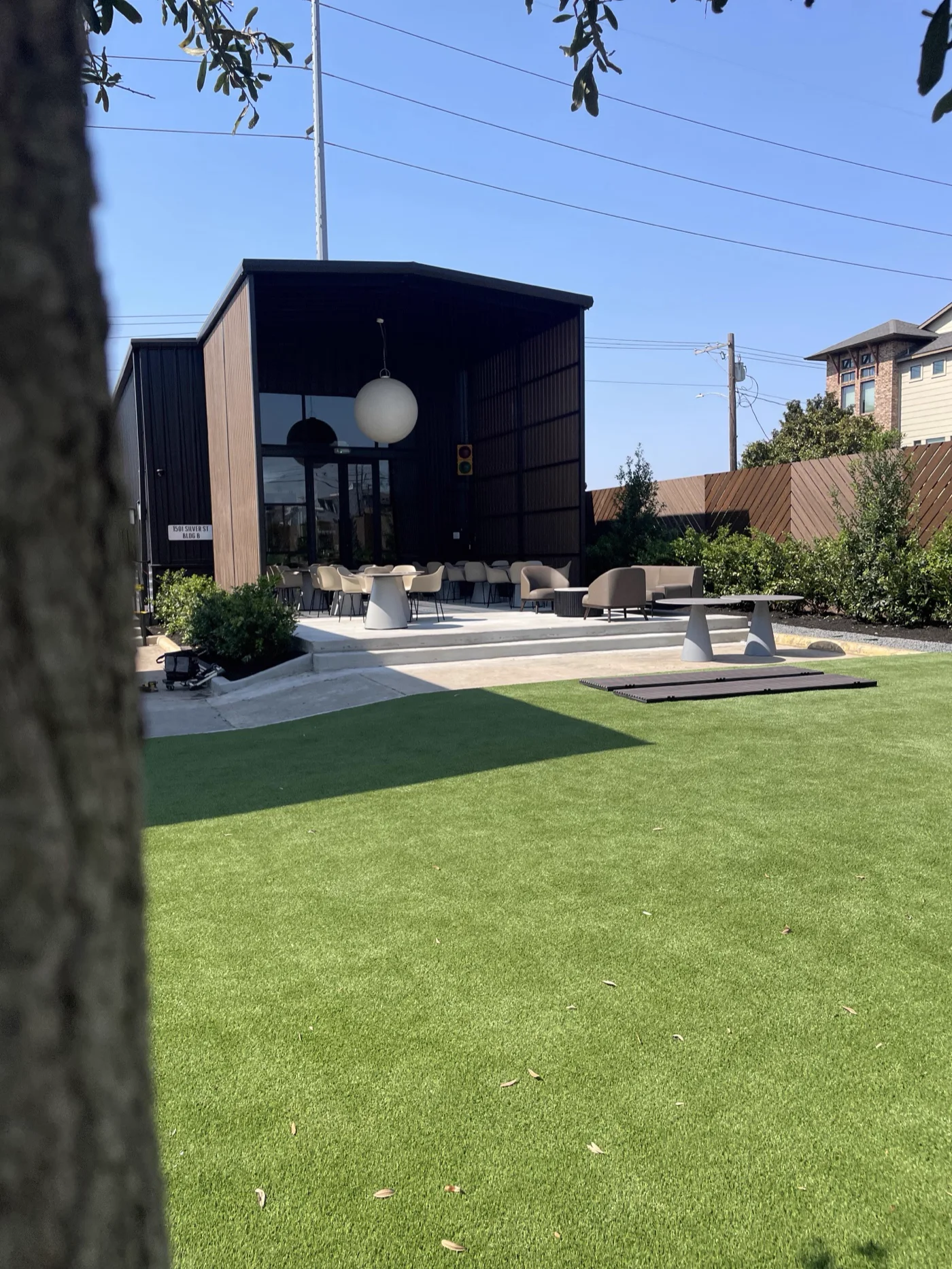 Outdoor lounge terrace with seating beside a steel-clad building