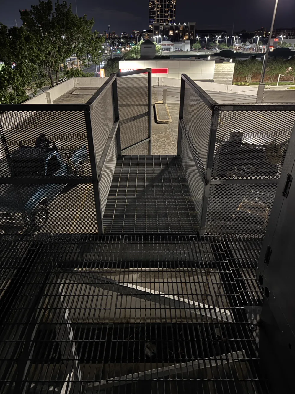Exterior steel stair with grating treads, expanded-metal guardrail and a steel screen