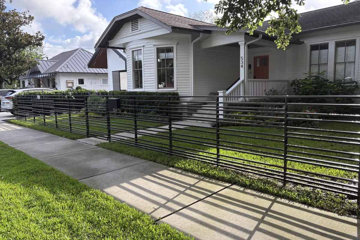 Horizontal-bar steel fence and privacy screen along a residential frontage