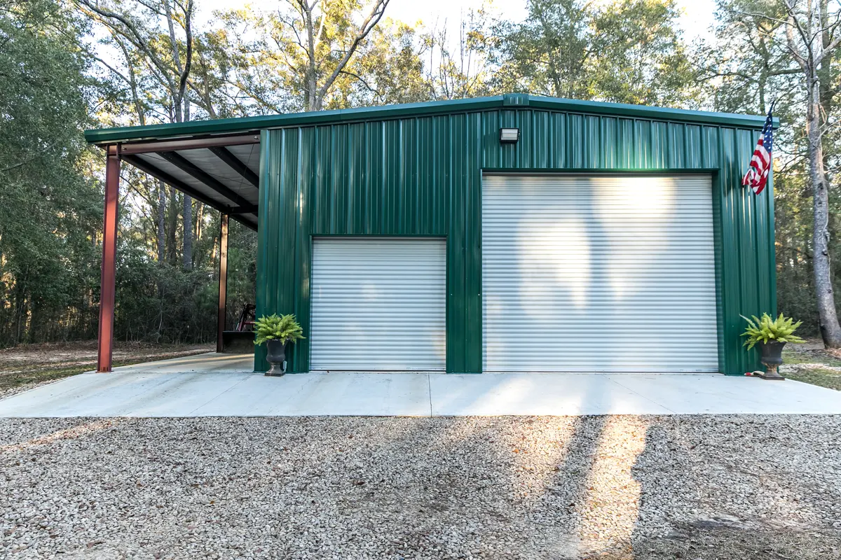 Custom metal shop building with roll-up doors and an attached steel carport